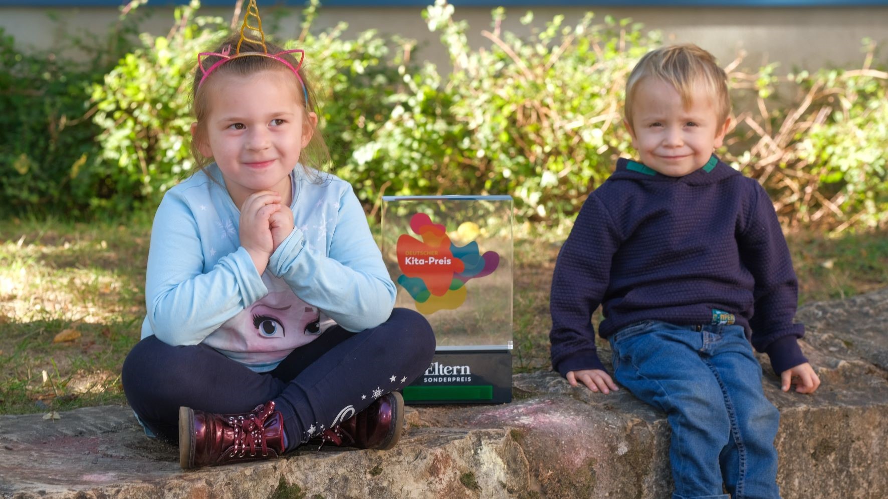 Zwei Kinder mit Trophäe des ELTERN-Sonderpreises