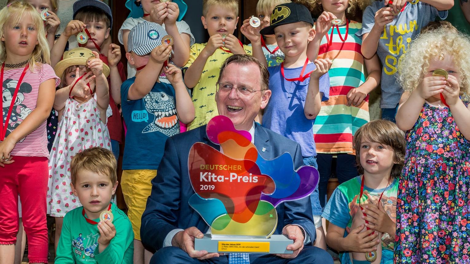 Ministerpräsident Bodo Ramelow und Kita-Kinder freuen sich über die Trophäe des Deutschen Kita-Preises