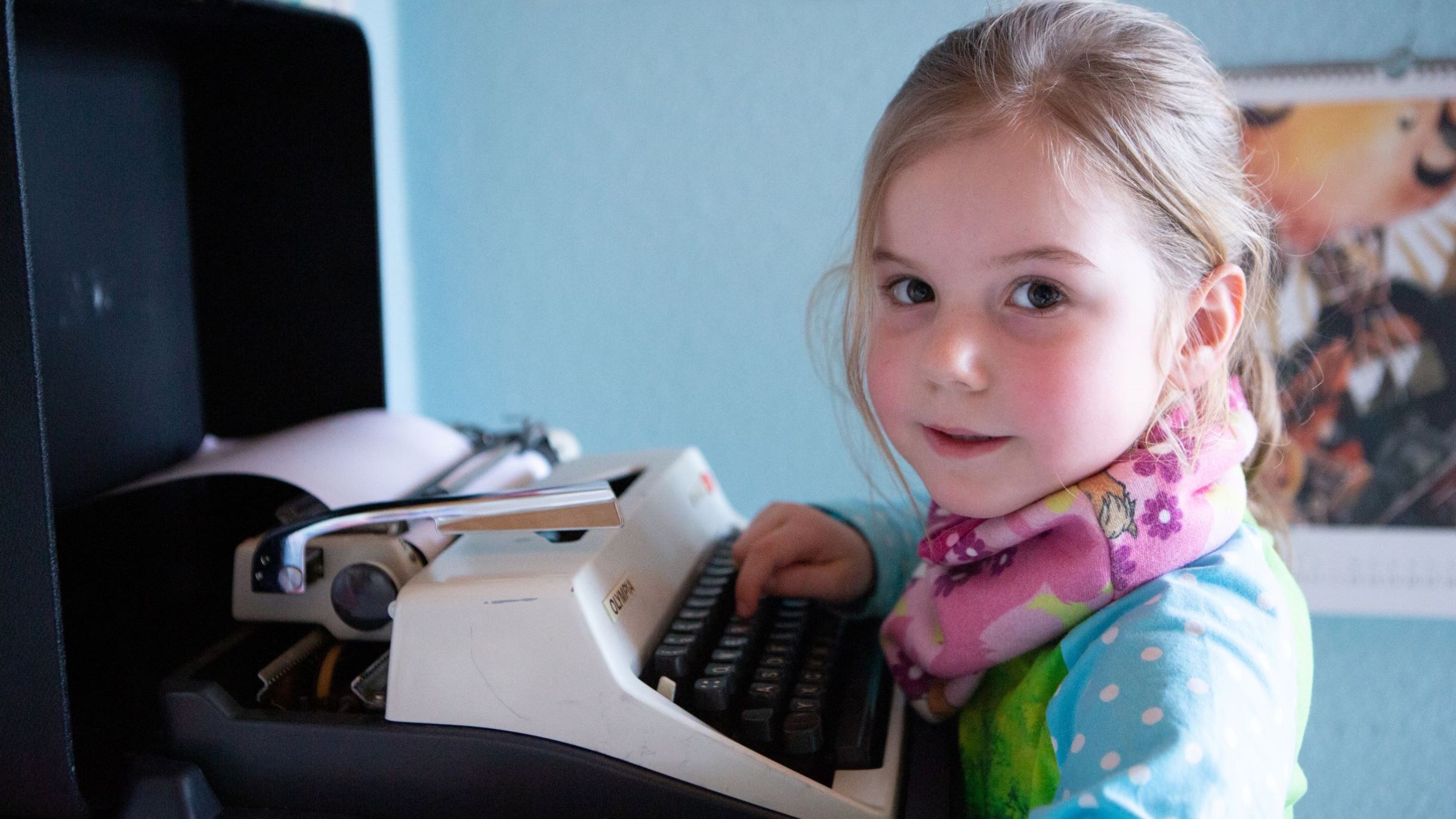 Mädchen tippt auf einer Schreibmaschine