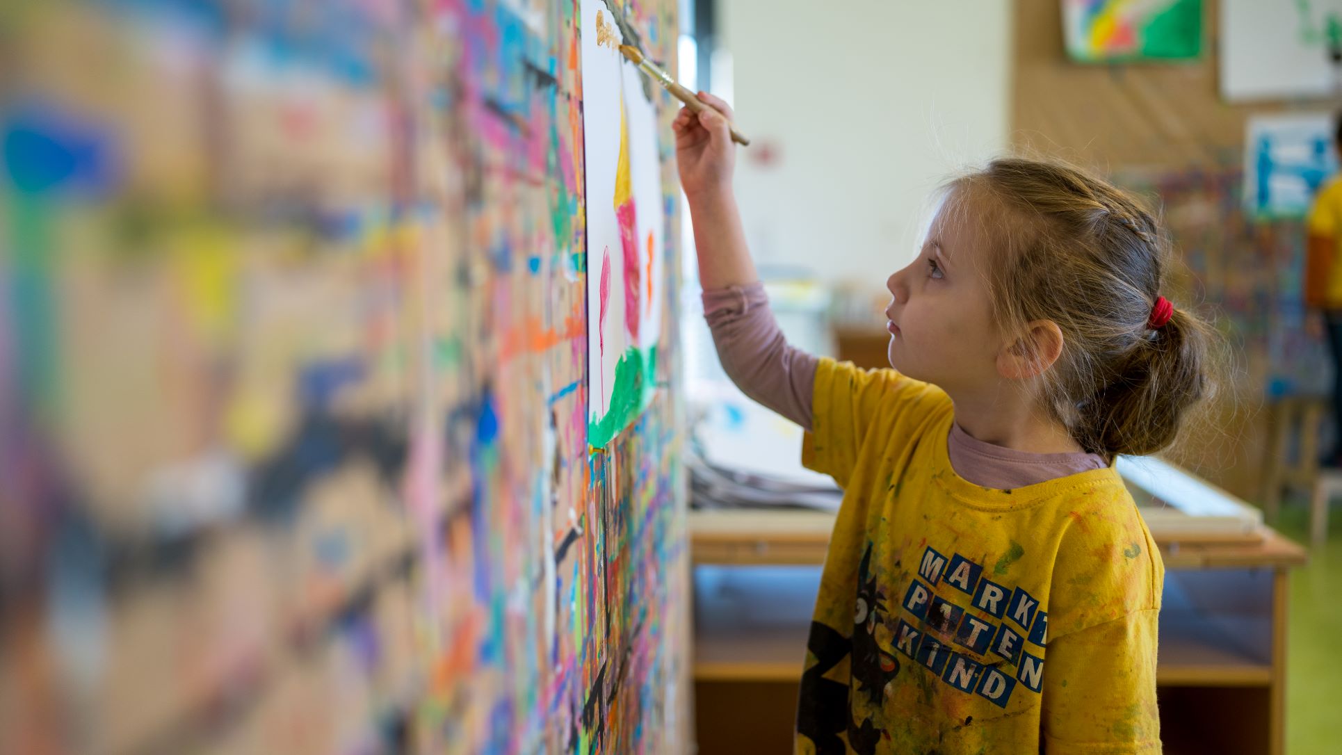 Ein Kind malt auf einer Leinwand