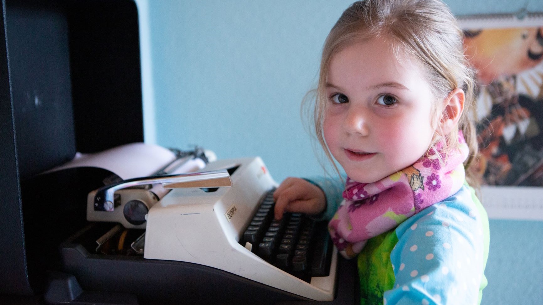 Mädchen tippt auf einer Schreibmaschine