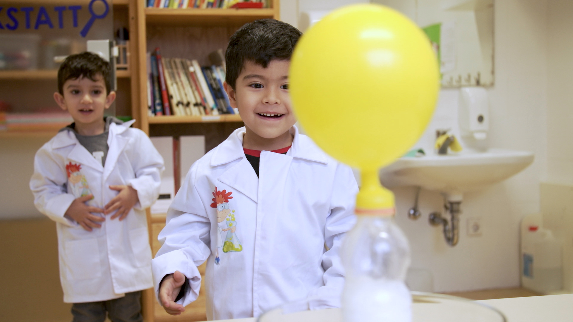Zwei Kinder zeigen Freude und Interesse beim Experimentieren.