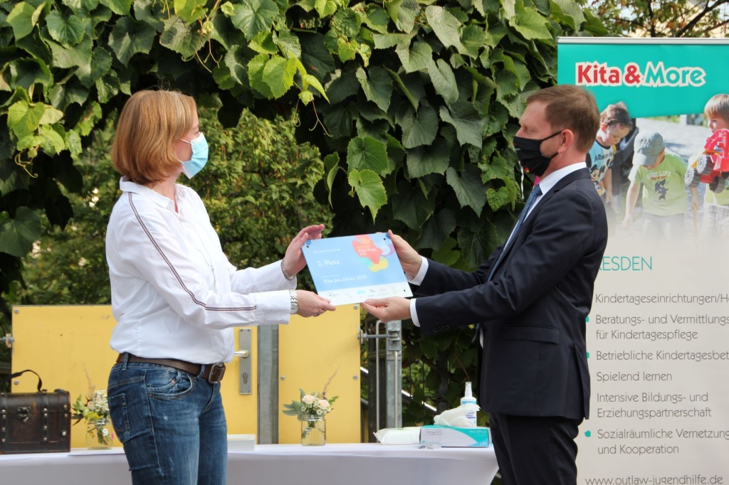 Ministerpräsident Michael Kretschmer überreicht Kita-Leiterin Katja Hillenbrand die Preisträger-Plakette