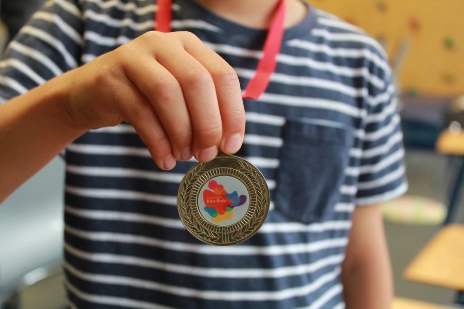 Ein Junge zeigt die Preisträger-Medaille
