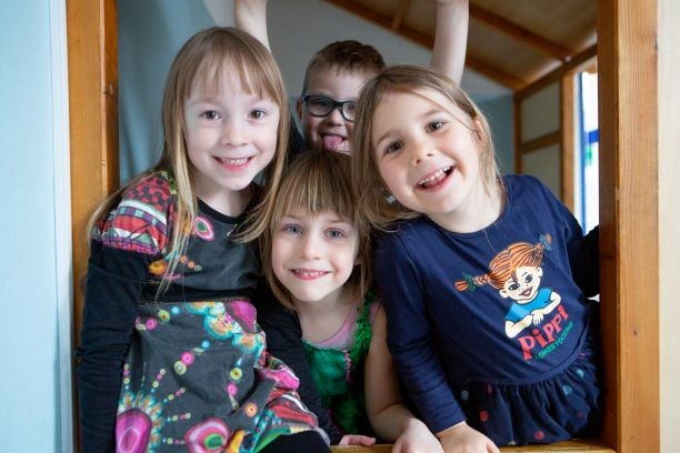 Vier Kita-Kinder lachen in die Kamera