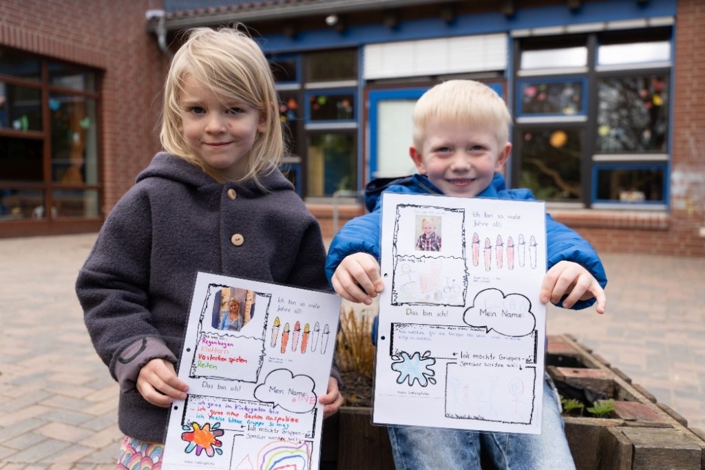 Kinder zeigen Zeichnungen